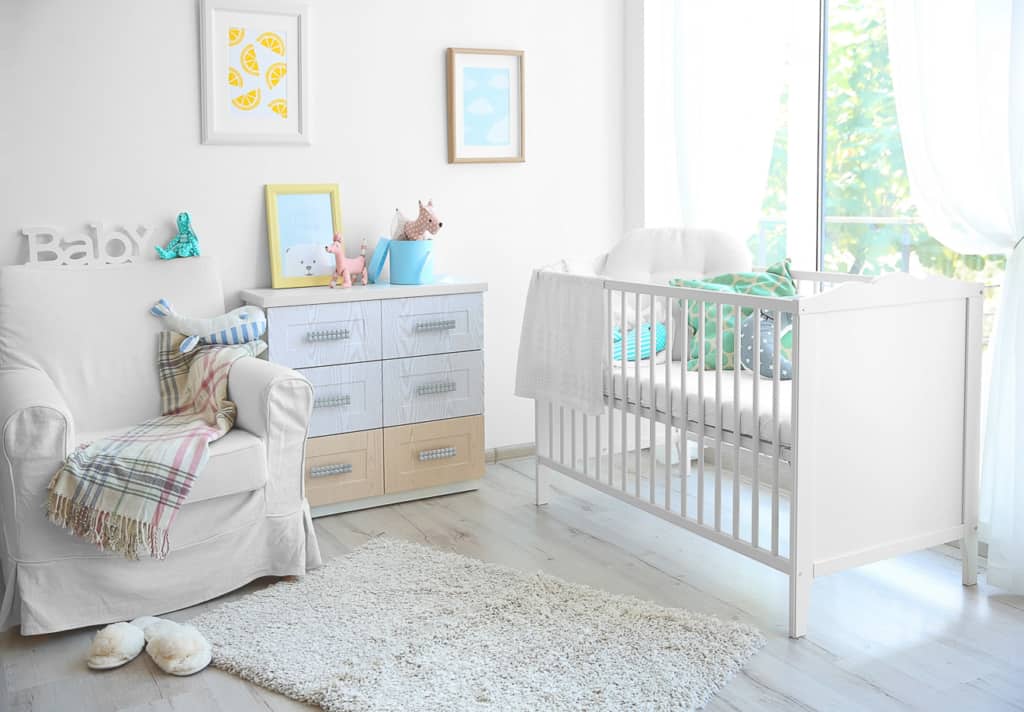 Inneneinrichtung des modernen Babyzimmers - Babybett mit Kommode